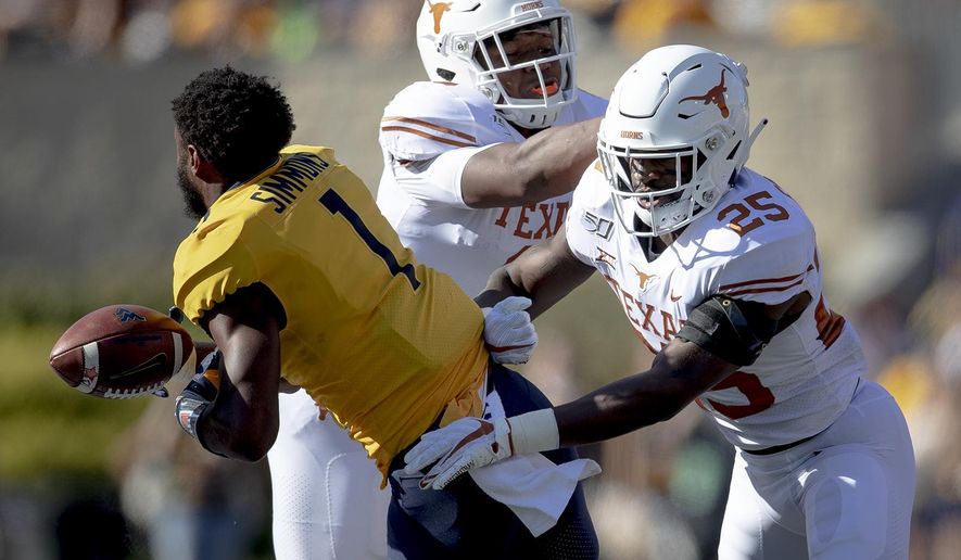 Texas defensive back B.J. Foster (25) shoves West Virginia wide receiver T.J. Simmons (1) during an NCAA college football game on Saturday, Oct. 5, 2019, in Morgantown, W.Va. (Nick Wagner/Austin American-Statesman via AP)