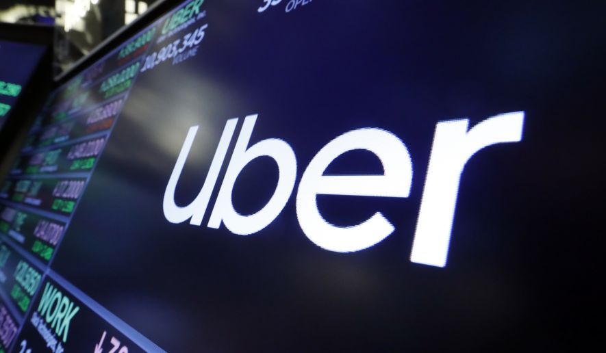 In this Friday, Aug. 16, 2019 file photo, the logo for Uber appears above a trading post on the floor of the New York Stock Exchange. (AP Photo/Richard Drew, file) **FILE**