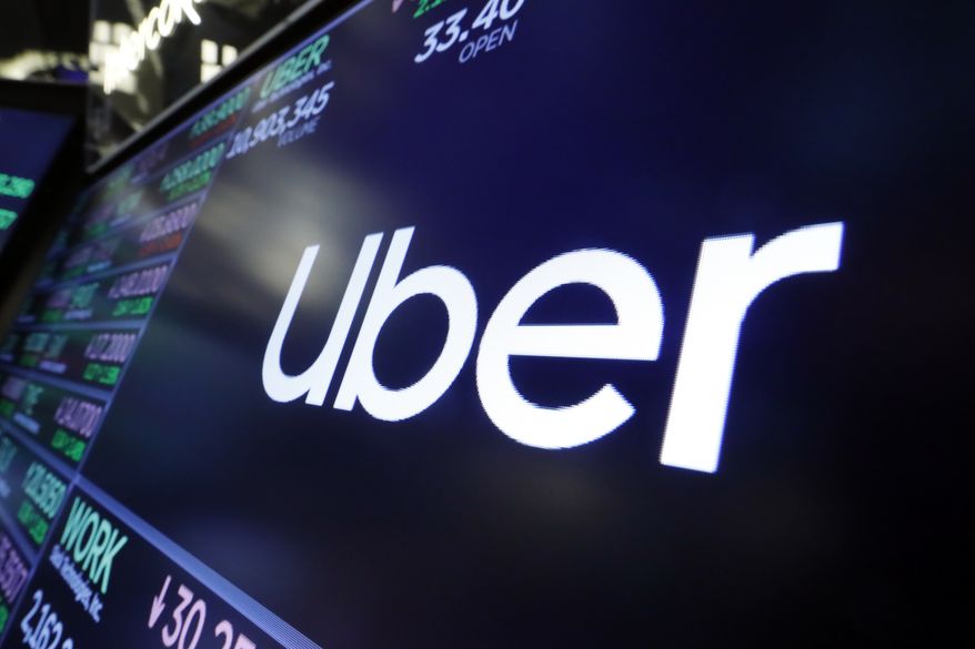 In this Friday, Aug. 16, 2019 file photo, the logo for Uber appears above a trading post on the floor of the New York Stock Exchange. (AP Photo/Richard Drew, file) **FILE**