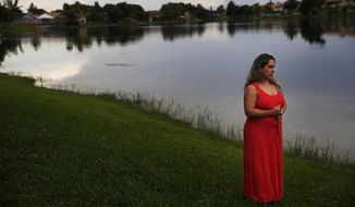In this Aug. 6, 2019, photo, Barbara Rodriguez poses for a photo outside of her home in Hialeah, Fla. Her husband, Pablo Sanchez, is seeking asylum in the U.S., but was placed in detention and is now facing deportation to Cuba. (AP Photo/Brynn Anderson)