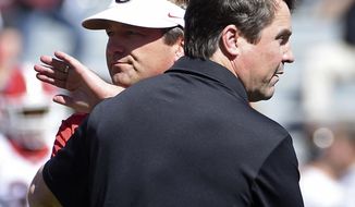 FILE - In this Oct. 9, 2016, file photo, Georgia head coach Kirby Smart, left, and South Carolina head coach Will Muschamp meet on the field before an NCAA college football game in Columbia, S.C. Kirby Smart remembers a time he didn’t feel like he could call Georgia teammate Will Muschamp a good friend. After all, Smart was just starting his playing career in 1994 and Muschamp was a senior. Now they will continue their SEC coaching rivalry when Smart’s No. 3 Georgia team plays Muschamp’s South Carolina team on Saturday. (AP Photo/Rainier Ehrhardt, File)