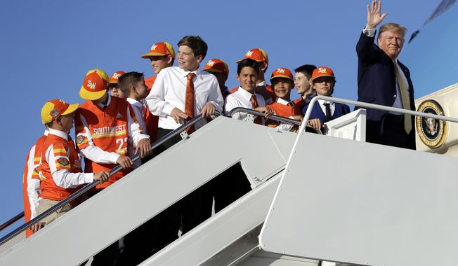 President Donald Trump boards Air Force One with Louisiana's Eastbank Little League team who won the 2019 Little League Baseball World Series Friday, Oct. 11, 2019, in Andrews Air Force Base, Md. Trump was heading to a campaign rally in Lake Charles, La. (AP Photo/Evan Vucci)