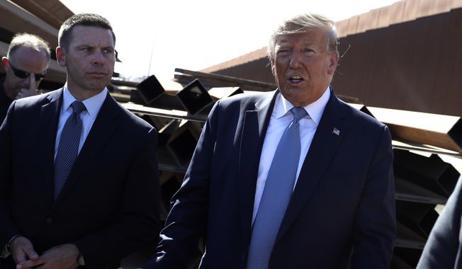 In this Sept. 18, 2019, photo, President Donald Trump talks with reporters as he tours a section of the southern border wall, in Otay Mesa, Calif., as acting Homeland Secretary Kevin McAleenan listens. (AP Photo/Evan Vucci) **FILE**