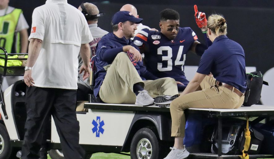 Virginia cornerback Bryce Hall (34) gestures as he leaves the field on a cart during the first half of an NCAA college football game against Miami, Friday, Oct. 11, 2019, in Miami Gardens, Fla. (AP Photo/Lynne Sladky)