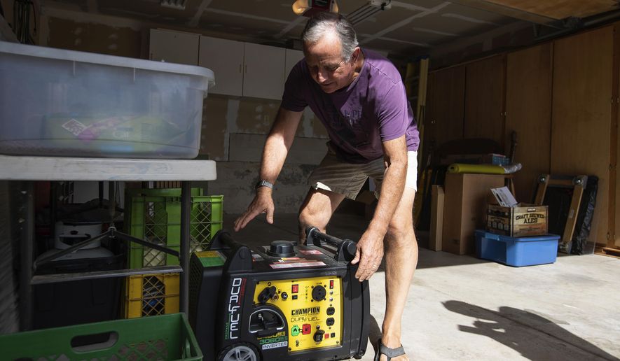 FILE - In this Tuesday, Oct. 8, 2019 file photo, Joe Wilson pulls his generator out in the garage of his home, which is in an area that is expected to lose power in the East Foothills area of San Jose, Calif. Power shutdowns intended to prevent more devastating California wildfires are raising concerns about another environmental threat: air pollution. As utilities temporarily halted service to more than 2 million people this week, many fired up standby generators that spew toxic emissions. (Randy Vazquez/San Jose Mercury News via AP, File)