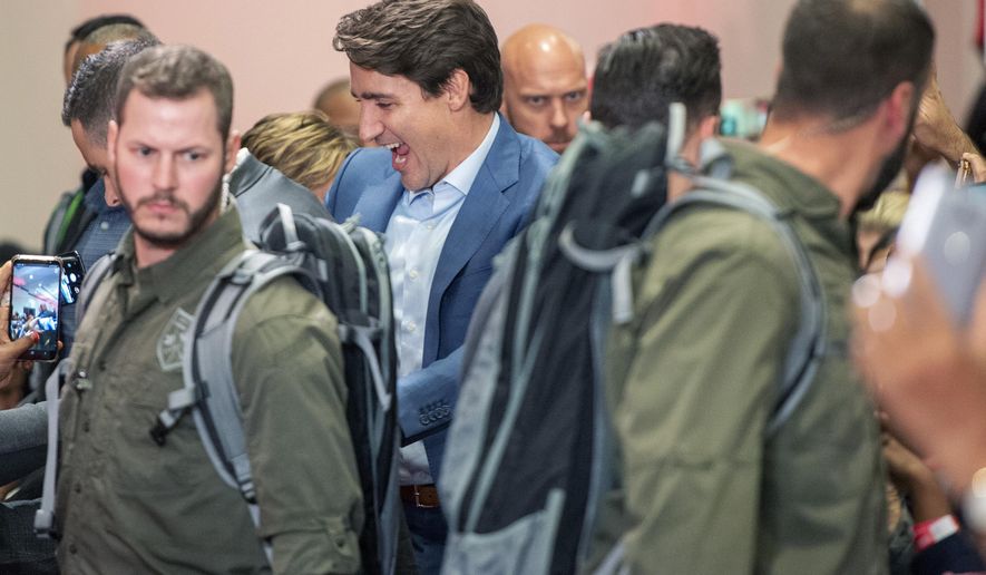 High profile security surrounds Liberal Leader Justin Trudeau as he arrives at a rally in Mississauga, Ontario, Saturday, Oct. 12, 2019. The rally was delayed for 90 minutes due to a security issue. (Frank Gunn/The Canadian Press via AP)
