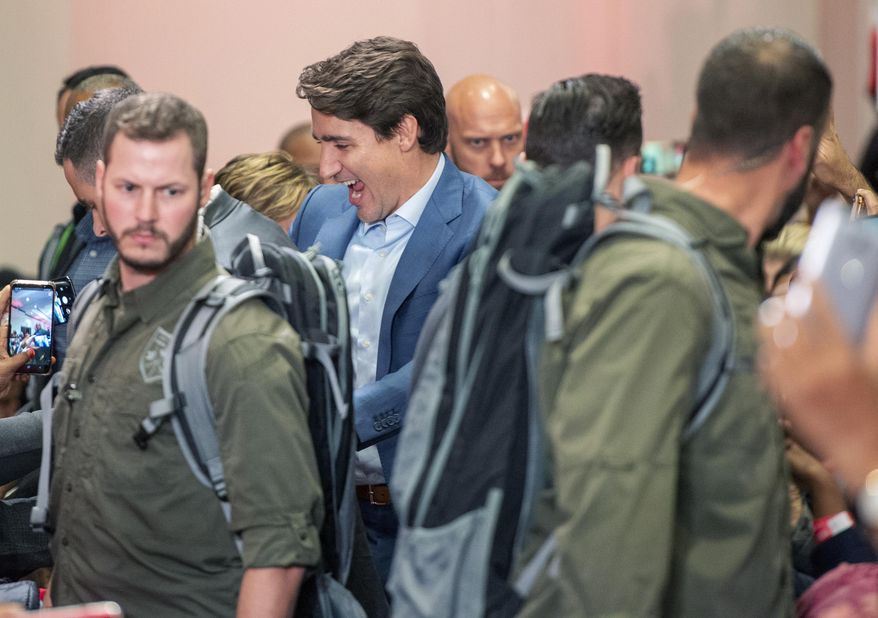 High profile security surrounds Liberal Leader Justin Trudeau as he arrives at a rally in Mississauga, Ontario, Saturday, Oct. 12, 2019. The rally was delayed for 90 minutes due to a security issue. (Frank Gunn/The Canadian Press via AP)