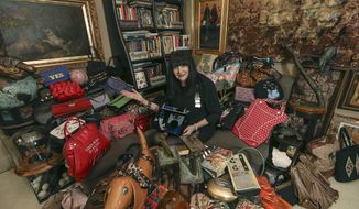 In this Thursday, Sept. 19, 2019 photo, Ilene Wood sits among her collection of handbags at her Lehigh Valley Estate in Emmaus, Pa.  Ilene Hochberg Wood&#x27;s collection of 3,000 handbags — the majority of which dwell in a 2,400-square-foot Quonset hut on her Lehigh Valley estate — will make a fashionista fall to her knees.  ( Steve M. Falk/The Philadelphia Inquirer via AP)