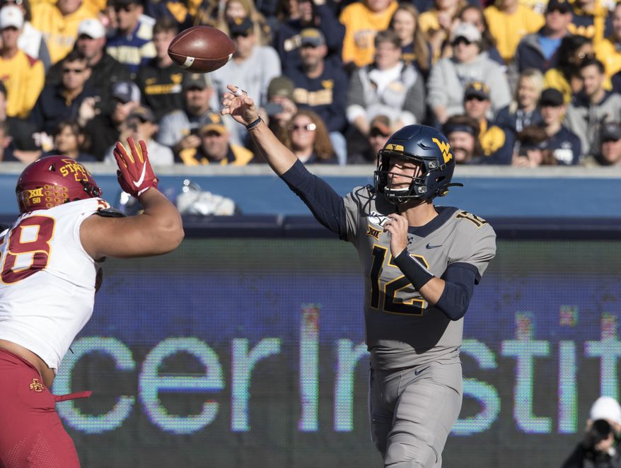 West Virginia quarterback Austin Kendall (12) attempts a pass during the first half of an NCAA college football game against Iowa State Saturday, Oct. 12, 2019, in Morgantown, W.Va. (AP Photo/Raymond Thompson)