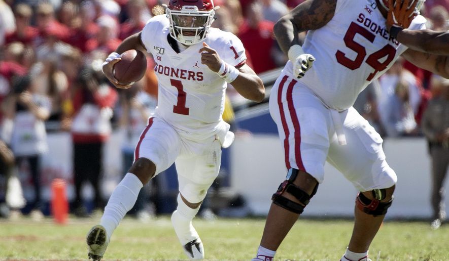 Oklahoma quarterback Jalen Hurts (1) runs against Texas behind the block of offensive lineman Marquis Hayes (54) in the second half of an NCAA college football game at the Cotton Bowl, Saturday, Oct. 12, 2019, in Dallas. Oklahoma won 34-27. (AP Photo/Jeffrey McWhorter)