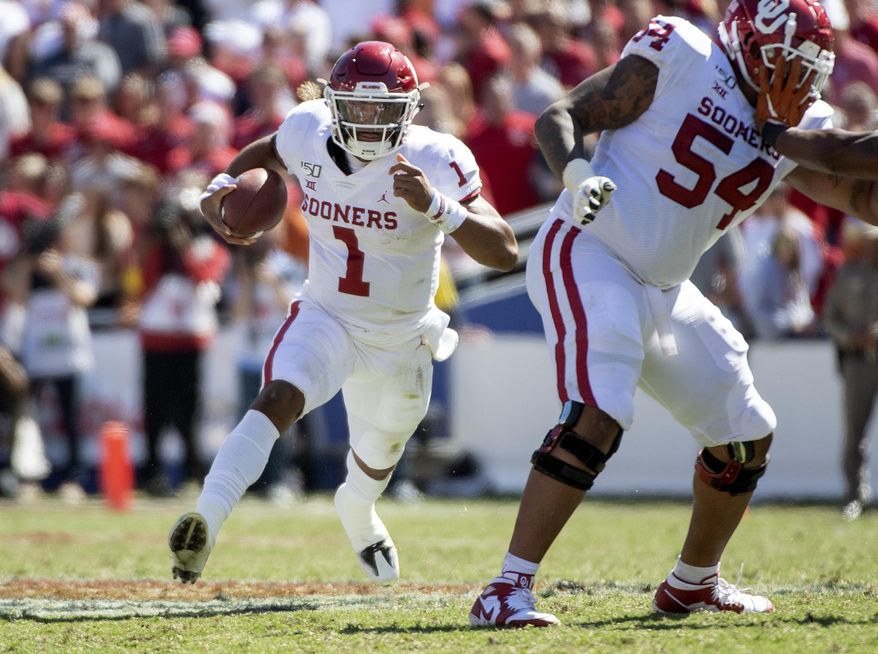 Oklahoma quarterback Jalen Hurts (1) runs against Texas behind the block of offensive lineman Marquis Hayes (54) in the second half of an NCAA college football game at the Cotton Bowl, Saturday, Oct. 12, 2019, in Dallas. Oklahoma won 34-27. (AP Photo/Jeffrey McWhorter)