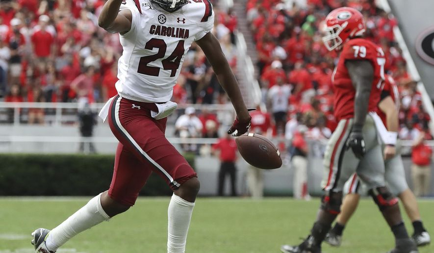 South Carolina defensive back Israel Mukuamu holds up three fingers after intercepting a pass during the first overtime period of an NCAA college football game, Saturday, Oct., 12, 2019, in Athens, Ga. (Curtis Compton/Atlanta Journal-Constitution via AP)