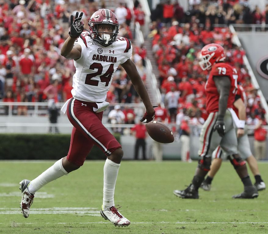South Carolina defensive back Israel Mukuamu holds up three fingers after intercepting a pass during the first overtime period of an NCAA college football game, Saturday, Oct., 12, 2019, in Athens, Ga. (Curtis Compton/Atlanta Journal-Constitution via AP)