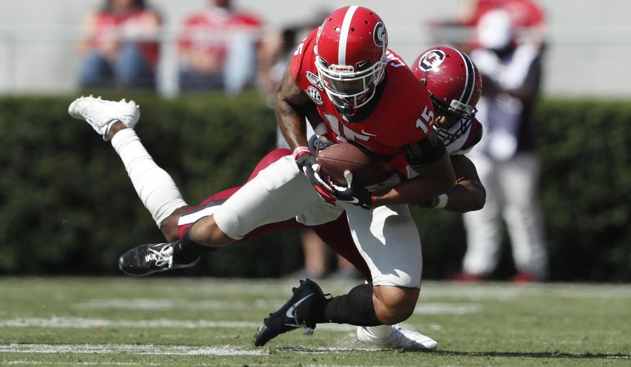 Georgia wide receiver Lawrence Cager (15) makes a catch as South Carolina defensive back Jaycee Horn (1) defends in the first half of an NCAA college football game Saturday, Oct. 12, 2019, in Athens, Ga. (AP Photo/John Bazemore)
