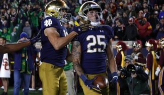Notre Dame wide receiver Braden Lenzy (25) celebrates his 51-yard touchdown run with Chris Finke (10) in the first half of an NCAA college football game against Southern California in South Bend, Ind., Saturday, Oct. 12, 2019. (AP Photo/Paul Sancya)