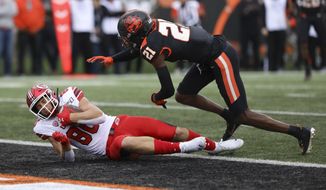 Utah tight end Brant Kuithe (80) lands in the end zone ahead of Oregon State defensive back Nahshon Wright (21) during the first half of an NCAA college football game in Corvallis, Ore., Saturday, Oct. 12, 2019. (AP Photo/Amanda Loman)