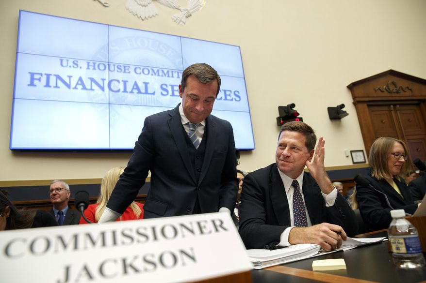 FILE - In this Sept. 24, 2019, file photo, Securities and Exchange Commission (SEC) Chairman Jay Clayton, center, waves to a commissioner as he takes his seat between SEC Commissioners Robert Jackson Jr., left, and Hester Peirce, at the start of a House Financial Services Committee hearing on Capitol Hill in Washington. With little fanfare, the SEC is taking steps to revamp one of the government’s most successful whistleblower programs, alarming advocates who warn the changes will set back efforts to police Wall Street and punish corporate fraud (AP Photo/Jacquelyn Martin, File)