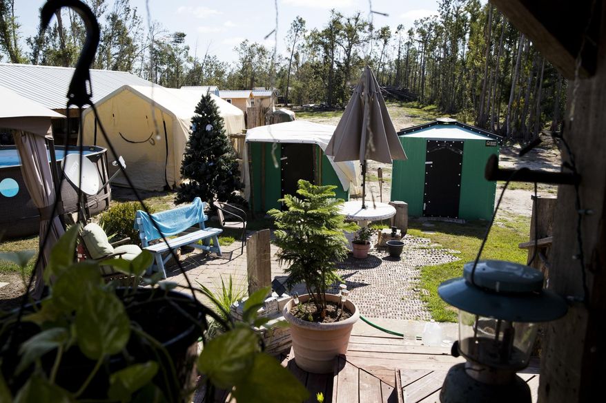 In this Thursday, Oct. 10, 2019 photo, Shelly Summers' backyard  has become a refuge for those left homeless from Hurricane Michael near Panama City, Fla. It has been a year since Hurricane Michael roared across the eastern Florida Panhandle, a Category 5 storm that laid waste to the coastline and ravaged areas far inland. Yet in rural Bay County, amid forests of snapped trees and the more-than-occasional home still roofed with a blue tarp. (Joshua Boucher/News Herald via AP)