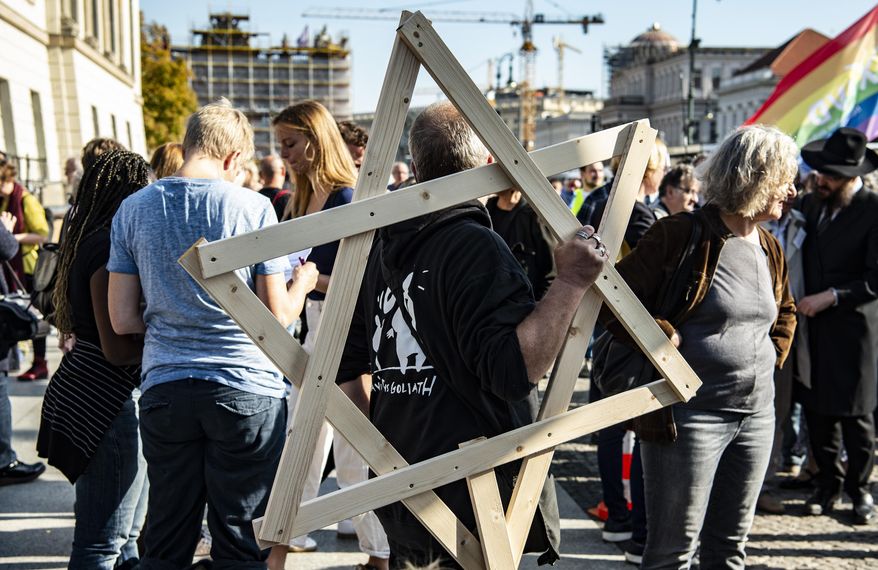 Thousands of people protest on Sunday, Oct. 13, 2019 in Berlin, Germany, against rising anti-Semitism, days after a man attacked a synagogue in the eastern German city of Halle. More than six thousand participated in the march through the German capital on Sunday. (Paul Zinken/dpa via AP)