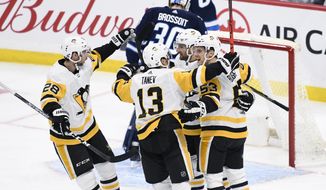 Pittsburgh Penguins&#39; Marcus Pettersson (28), Brandon Tanev (13) and Teddy Blueger (53) celebrate with Zach Aston-Reese after Aston-Reese&#39;s goal agains Winnipeg Jets goaltender Laurent Brossoit (30) during first-period NHL hockey game action in Winnipeg, Manitoba, Sunday, Oct. 13, 2019. (Fred Greenslade/The Canadian Press via AP)