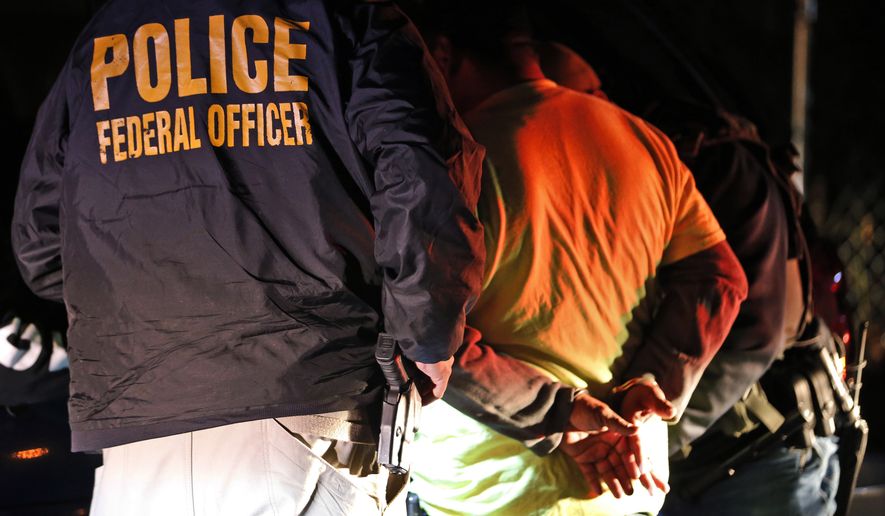 In this Oct. 22, 2018, file photo, U.S. Immigration and Customs Enforcement agents detain a person during a raid in Richmond, Va. (AP Photo/Steve Helber, File)