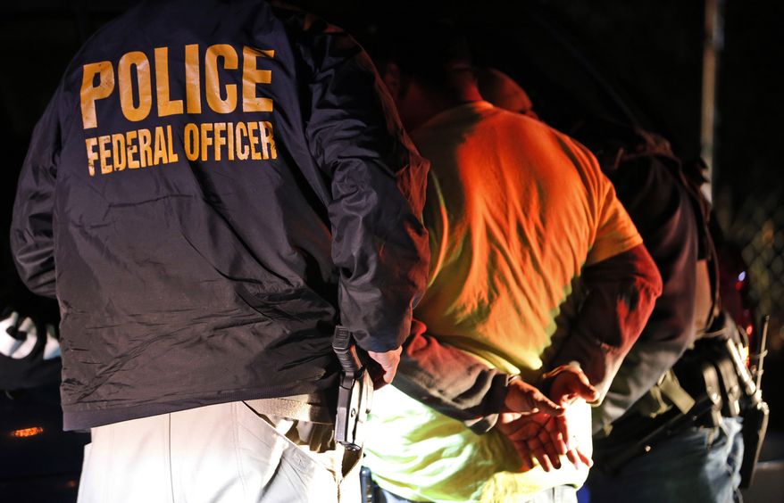 In this Oct. 22, 2018, file photo, U.S. Immigration and Customs Enforcement agents detain a person during a raid in Richmond, Va. (AP Photo/Steve Helber, File) ** FILE* *