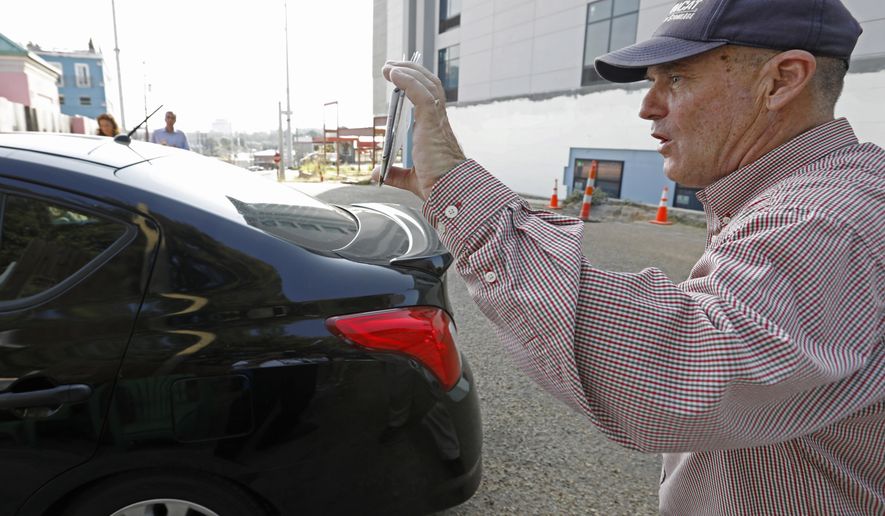 Anti abortion activist Doug Lane, calls out to a woman driving into the Jackson Women's Health Organization clinic in Jackson, Miss., Wednesday, Oct. 2, 2019. The Jackson City Council voted 3-1 Tuesday to enact a local law limiting amplified sound outside health care facilities and creating buffer zones to move protesters further from the entrances. The law is set to take effect in about a month, and opponents say it unconstitutionally limits their right to free speech. A court challenge is likely. (AP Photo/Rogelio V. Solis)