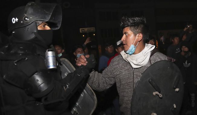 One of the protesters shakes hands with a security officer as they celebrate the announcement that the government cancelled an austerity package that triggered violent protests, in Quito, Ecuador, Sunday, Oct. 13, 2019. Ecuadorian President Lenin Moreno and leaders of the country&#x27;s indigenous peoples have struck a deal to cancel the disputed austerity package and end nearly two weeks of protests that have paralyzed the economy and left several people dead. (AP Photo/Dolores Ochoa)