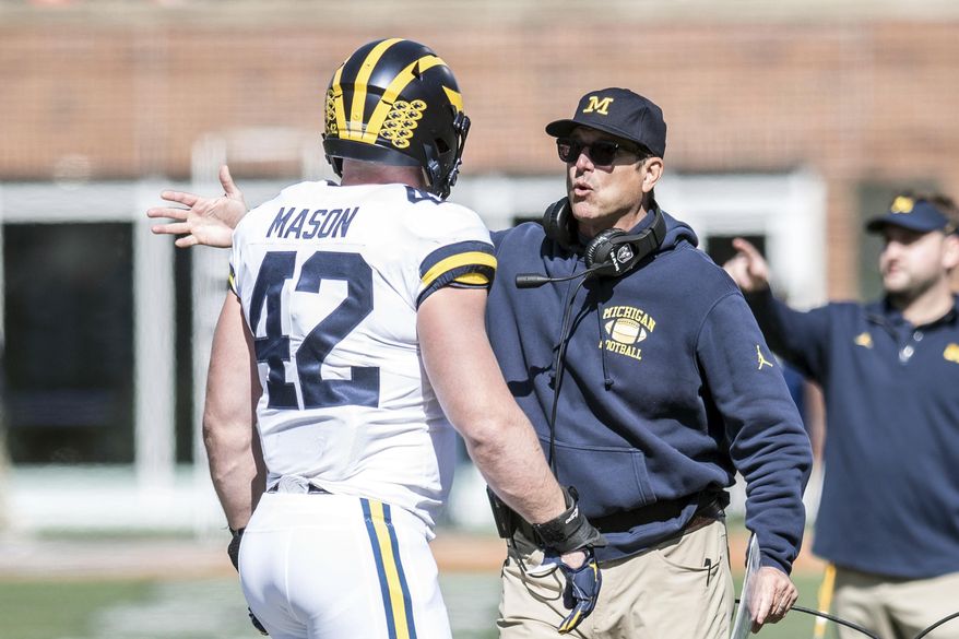 Michigan coach Jim Harbaugh talks with Ben Mason during the first half of an NCAA college football game against Illinois, Saturday, Oct. 12, 2019, in Champaign, Ill. (AP Photo/Holly Hart)
