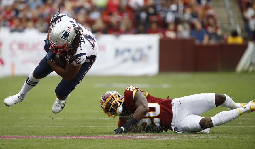 New England Patriots fullback Jakob Johnson (47)- is tripped up by Washington Redskins strong safety Landon Collins (20) during the first half of an NFL football game, Sunday, Oct. 6, 2019, in Landover, Md. (AP Photo/Patrick Semansky)