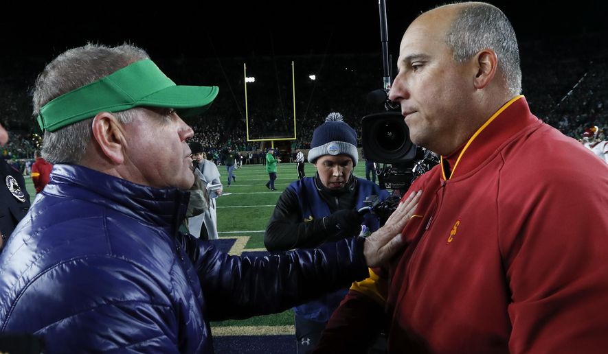 Notre Dame head coach Brian Kelly, left, and Southern California head coach Clay Helton meet after an NCAA college football game in South Bend, Ind., Saturday, Oct. 12, 2019. (AP Photo/Paul Sancya)