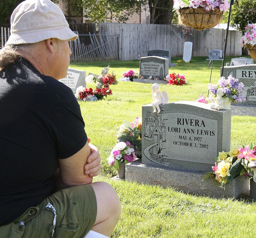 Marion Lewis sits at his daughter Lori's grave site on Oct. 15, 2009 in Mountain Home, Id. Lori Ann Lewis-Rivera was vacuuming cereal from her minivan Oct. 3, 2002 at a gas station near her Silver Springs, Md. home when she was shot down by Washington, D.C. area John Allen Muhammad and his young accomplice, Lee Boyd Malvo. (AP Photo/Matt Cilley)
