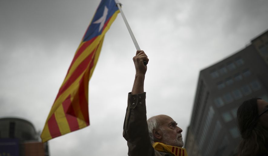 A man waves an Estelada pro Catalonia independence flag during a protest in Brussels, Tuesday, Oct. 15, 2019. New disruptions to Catalonia&#39;s transportation network on Tuesday followed a night of clashes between activists and police over the conviction of separatist leaders, as Spanish authorities announced an investigation into the group organizing the protests. (AP Photo/Francisco Seco)