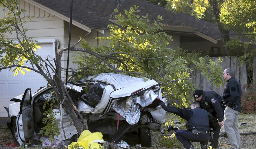 In this Monday, Oct. 14, 2019 photo, police investigate the scene of fatal crash involving a suspected drunken driver in Santa Rosa, Calif. Authorities in Northern California say a 21-year-old man suspected of driving while intoxicated crashed his car against a parked SUV, killing a homeless woman and her dog sleeping inside. (Beth Schlanker/The Press Democrat via AP)