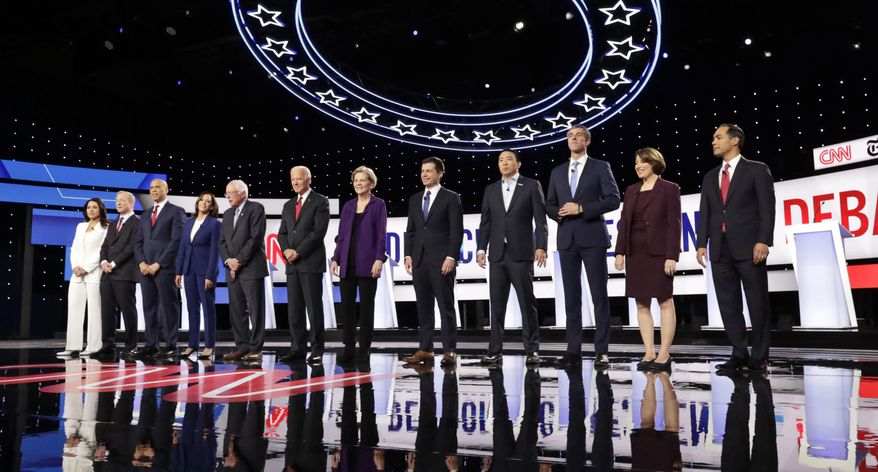 From left, Democratic presidential candidates, Rep. Tulsi Gabbard, D-Hawaii, businessman Tom Steyer, Sen. Cory Booker, D-N.J., Sen. Kamala Harris, D-Calif., Sen. Bernie Sanders, I-Vt., former Vice President Joe Biden, Sen. Elizabeth Warren, D-Mass., South Bend Mayor Pete Buttigieg, entrepreneur Andrew Yang, former Texas Rep. Beto O'Rourke, Sen. Amy Klobuchar, D-Minn., and former Housing Secretary Julian Castro stand on stage for a photo before a Democratic presidential primary debate hosted by CNN and The New York Times at Otterbein University, Tuesday, Oct. 15, 2019, in Westerville, Ohio. (AP Photo/Tony Dejak)