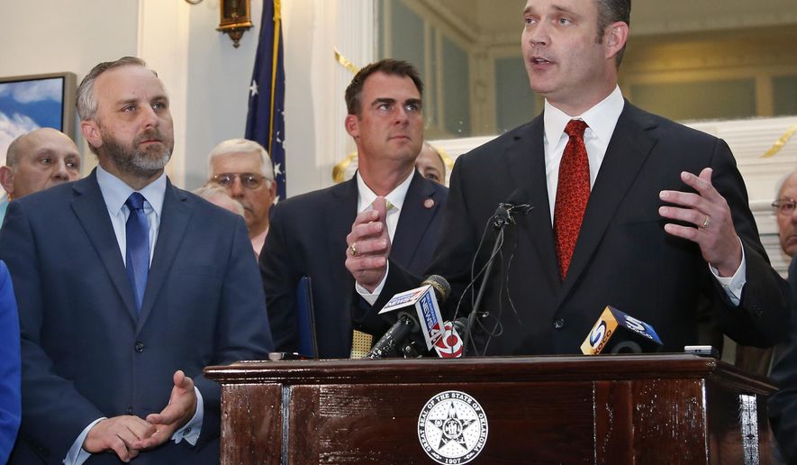 FILE - In this May 15, 2019, file photo, Oklahoma Senate President Pro Tempore Greg Treat, left, Oklahoma Gov. Kevin Sitt, center, look on as Oklahoma House Speaker Charles McCall speaks during a joint news conference at the Capitol in Oklahoma City. The Legislative Compensation Board, that sets the salaries of Oklahoma lawmakers has voted to boost legislative pay by 35% next year. The board voted Tuesday, Oct. 15, 2019, to boost legislators' pay from $35,021 to $47,500. The Oklahoman reports that it's the first pay raise for legislators in the past 20 years. (AP Photo/Sue Ogrocki, File)
