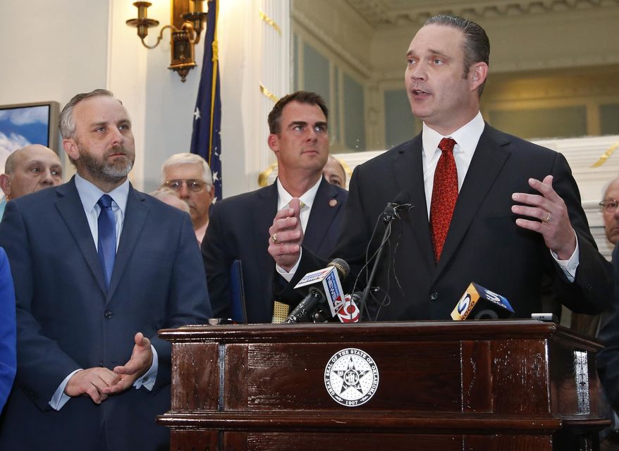 FILE - In this May 15, 2019, file photo, Oklahoma Senate President Pro Tempore Greg Treat, left, Oklahoma Gov. Kevin Sitt, center, look on as Oklahoma House Speaker Charles McCall speaks during a joint news conference at the Capitol in Oklahoma City. The Legislative Compensation Board, that sets the salaries of Oklahoma lawmakers has voted to boost legislative pay by 35% next year. The board voted Tuesday, Oct. 15, 2019, to boost legislators' pay from $35,021 to $47,500. The Oklahoman reports that it's the first pay raise for legislators in the past 20 years. (AP Photo/Sue Ogrocki, File)