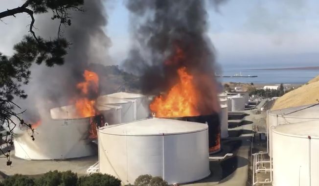 In this image from video provided by the Napa County Sheriff's Office, tanks are on fire at an oil storage facility Tuesday, Oct. 15, 2019, in Rodeo, Calif. A fire burning at an oil storage facility in the San Francisco Bay Area prompted a hazardous materials emergency that led authorities to order the residents of two communities to shelter in place and stay inside with all windows and doors closed. Contra Costa Fire Department spokesman Steve Hill said that an hour into battling the blaze, firefighters seemed to be making progress and were continuing to keep adjacent tanks cooled with water. (Henry Wofford/Napa County Sheriff's Office via AP)