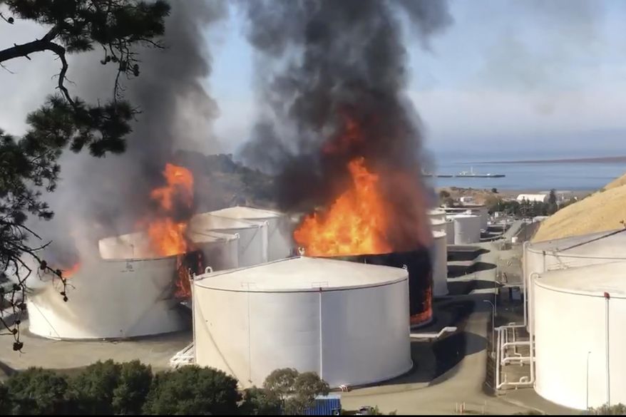 In this image from video provided by the Napa County Sheriff's Office, tanks are on fire at an oil storage facility Tuesday, Oct. 15, 2019, in Rodeo, Calif. A fire burning at an oil storage facility in the San Francisco Bay Area prompted a hazardous materials emergency that led authorities to order the residents of two communities to shelter in place and stay inside with all windows and doors closed. Contra Costa Fire Department spokesman Steve Hill said that an hour into battling the blaze, firefighters seemed to be making progress and were continuing to keep adjacent tanks cooled with water. (Henry Wofford/Napa County Sheriff's Office via AP)