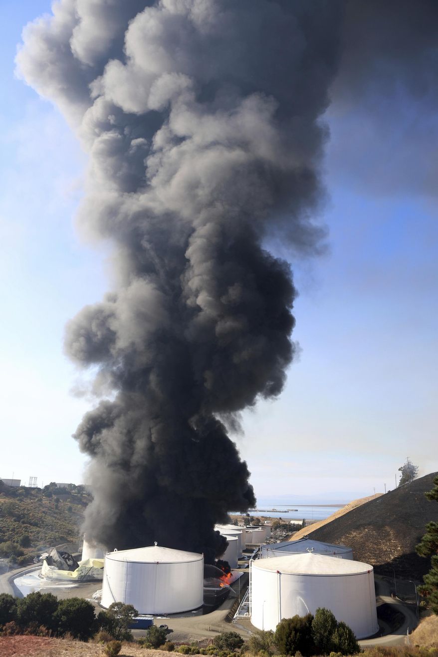 Oil storage facility tanks burn in Crockett, Calif. on Tuesday, Oct. 15, 2019. Emergency sirens blared and thick plumes of black smoke and flames filled the skyline around the NuStar Energy LP facility in Crockett, about 30 miles northeast of San Francisco. "This is a very dynamic, rapidly evolving situation," Capt. George Laing of the Contra Costa Fire Department said. (Anda Chu/San Jose Mercury News via AP)