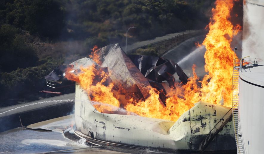 A tank burns as fire breaks out at a refinery in Crockett, Calif., on Tuesday, Oct. 15, 2019. A fire burning at an oil storage facility in the San Francisco Bay Area prompted a hazardous materials emergency that led authorities to order the residents of two communities to shelter in place and stay inside with all windows and doors closed. Contra Costa Fire Department spokesman Steve Hill said that an hour into battling the blaze, firefighters seemed to be making progress and were continuing to keep adjacent tanks cooled with water. (Anda Chu/San Jose Mercury News via AP)