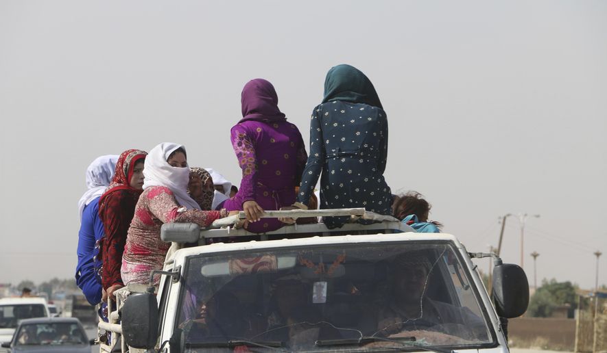 Women sit on top of a pickup truck as they travel along a road near Hasakeh, some 100km south of the border with Turkey, in northeastern Syria, on Friday, Oct. 11, 2019. The United Nations World Food Programme (WFP) announced Tuesday, Oct. 15, 2019 that WFP has provided so far immediate food assistance to more than 83,000 internally displaced people fleeing hostilities in northeastern Syria and that it has the capacity to provide ready-to-eat food packages to over 450,000 people. (Alan Ali/WFP via AP)