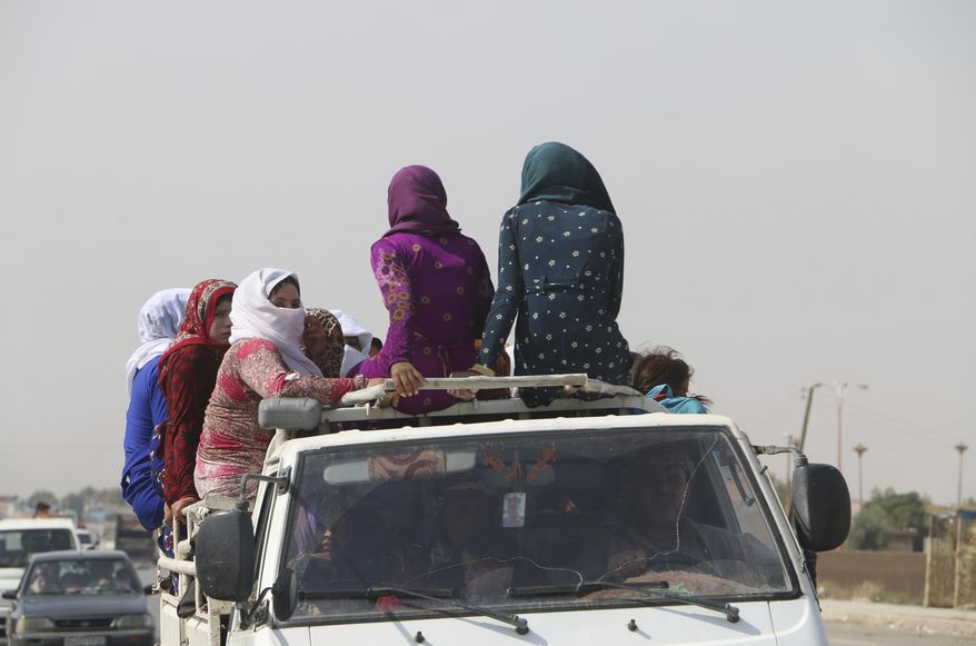 Women sit on top of a pickup truck as they travel along a road near Hasakeh, some 100km south of the border with Turkey, in northeastern Syria, on Friday, Oct. 11, 2019. The United Nations World Food Programme (WFP) announced Tuesday, Oct. 15, 2019 that WFP has provided so far immediate food assistance to more than 83,000 internally displaced people fleeing hostilities in northeastern Syria and that it has the capacity to provide ready-to-eat food packages to over 450,000 people. (Alan Ali/WFP via AP)