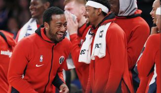 Washington Wizards guard John Wall, left, who is recovering from an Achilles injury, laughs as he watches from the bench with teammates during the waning moments of the team&#39;s preseason NBA basketball game against the New York Knicks in New York, Friday, Oct. 11, 2019. (AP Photo/Kathy Willens)