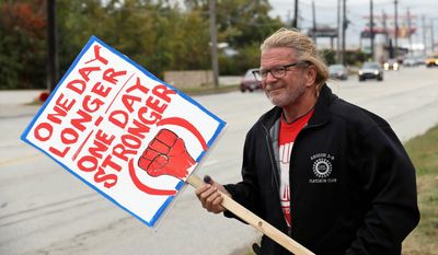 John Harbert, a 42-year General Motors employee, and others are expected to continue picketing outside the GM Fabrication Division through Friday as bargainers for General Motors and the United Auto Workers iron out details of a tentative contract. (Associated Press)
