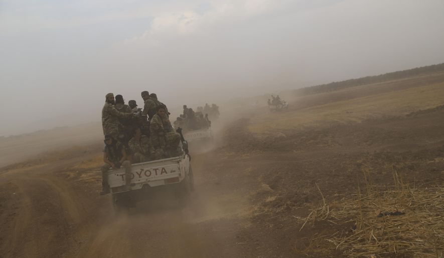 A convoy of Turkish backed Free Syria Army is about to cross into Turkey near the town of Azaz, Syria, Wednesday, Oct. 16, 2019. (AP Photo)