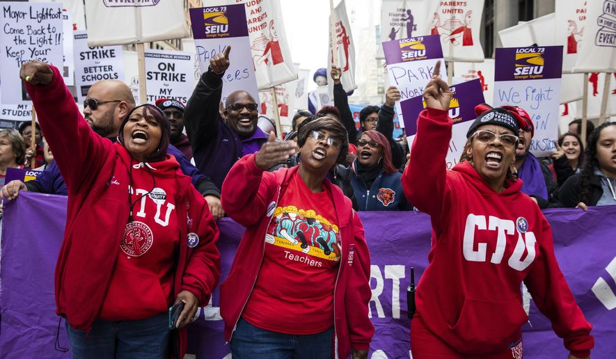 In this Oct. 14, 2019, file photo, members of the Chicago Teachers Union and SEIU Local 73 march through the Loop after a rally, three days before the unions could walk off the job on strike. (Ashlee Rezin Garcia/Chicago Sun-Times via AP) ** FILE **