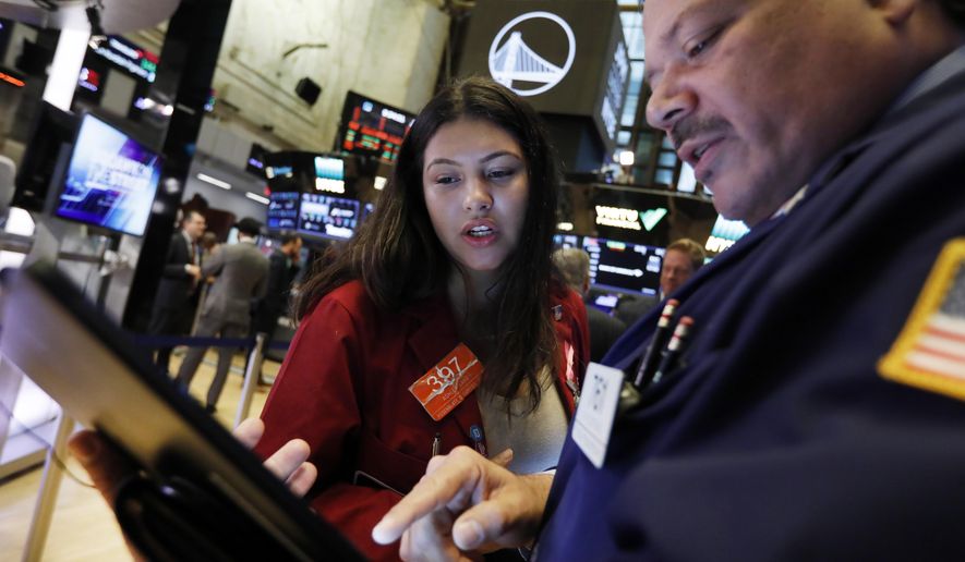 FILE - In this Oct. 7, 2019, file photo traders Ashley Lara and John Santiago confer as they work on the floor of the New York Stock Exchange. The U.S. stock market opens at 9:30 a.m. EDT on Wednesday, Oct. 16. (AP Photo/Richard Drew, File)