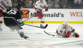 Carolina Hurricanes center Martin Necas, right, falls while trying to pass the puck as Los Angeles Kings center Trevor Lewis defends during the first period of an NHL hockey game Tuesday, Oct. 15, 2019, in Los Angeles. (AP Photo/Mark J. Terrill)