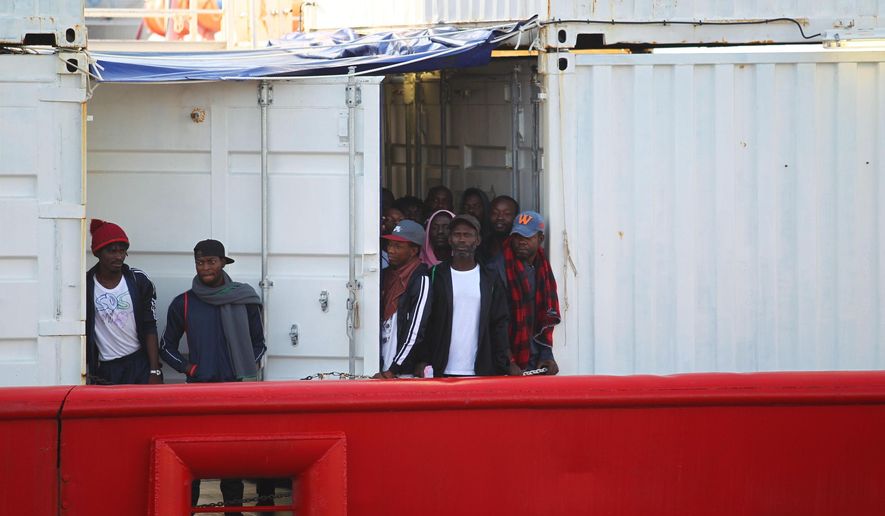 Migrants aboard the Ocean Viking rescue ship look around as they enter in the commercial port of Taranto, in Taranto, southern Italy, Wednesday, Oct. 16, 2019. The ship run by SOS Mediterranee rescued 176 migrants. (Ingenito/ANSA via AP)
